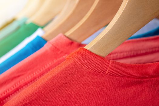 Fashion T-shirt on clothing rack - Closeup of bright colorful closet on wooden hangers in store closet