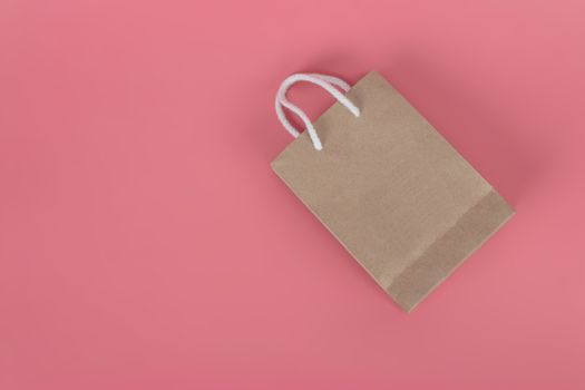 Paper bags on pastel pink backgrounds, environmental conservation concept