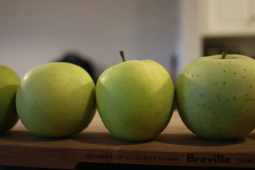 green apples in a row. good concept photo.