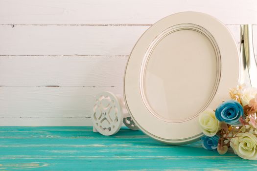 White vintage photo frame on table with decoration background.