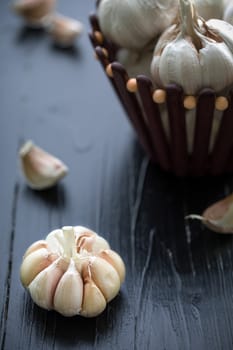 Raw garlic on black wooden table background.