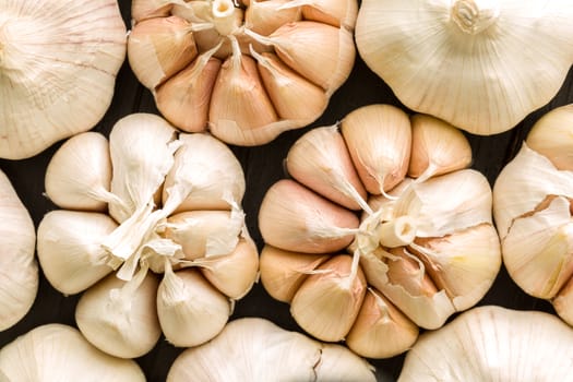 Raw garlic on black wooden table background.