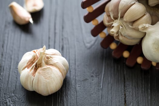 Raw garlic on black wooden table background.