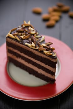 Almond chocolate cake on black wooden table.