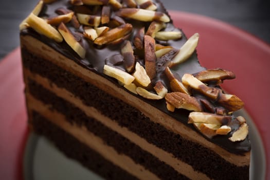 Almond chocolate cake on black wooden table.