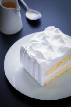 White cake for tea break moment on black background.