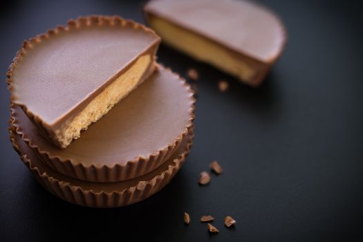 Stack of chocolate peanut butter cup on black background.