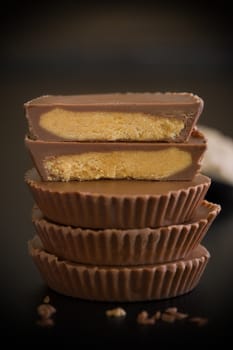 Stack of chocolate peanut butter cup on black background.