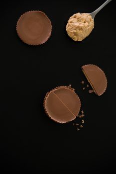 Stack of chocolate peanut butter cup on black background.