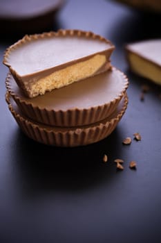 Stack of chocolate peanut butter cup on black background.