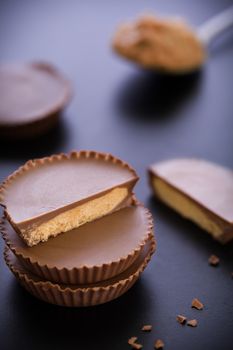 Stack of chocolate peanut butter cup on black background.