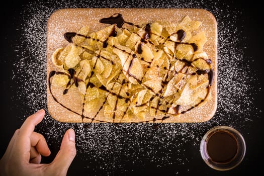 Banana chips with icing sugar and chocolate sauce.