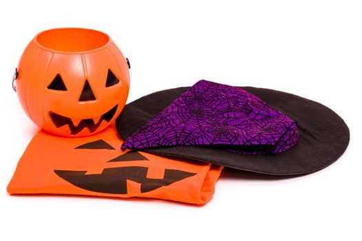 Halloween costume, witch hat, and pumpkin for Halloween night.