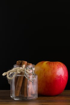 Fresh red apple with cinnamon bark stick.