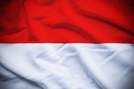Wavy and rippled national flag of Monaco background.