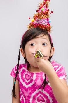 Little girl celebrates her birthday on isolated white background.