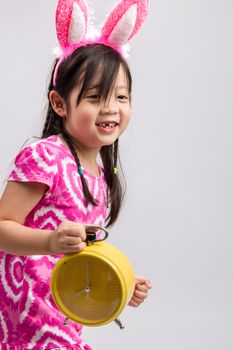Child holding clock illustrating time concept on white background.