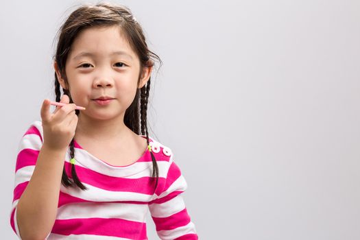 Happy little girl eating snack on white background.