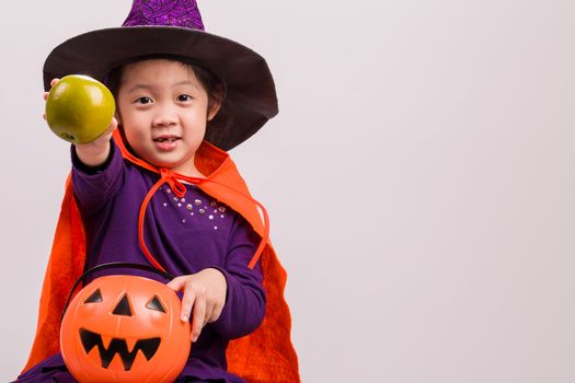 Child in Halloween costume with big pumpkin.