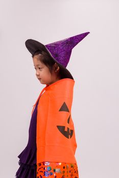 Child in Halloween costume with big pumpkin.