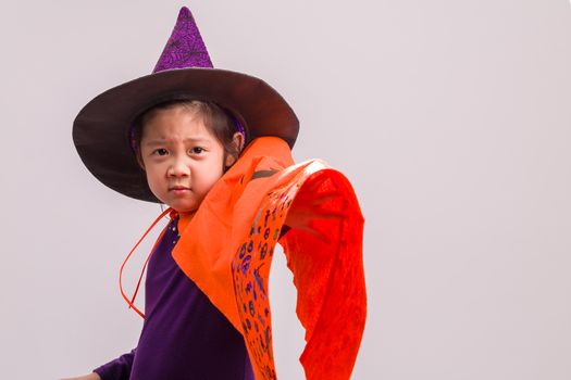 Child in Halloween costume with big pumpkin.