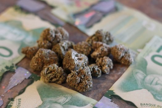 Marijuana and canadian money on a granite counter.