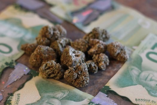 Marijuana and canadian money on a granite counter.