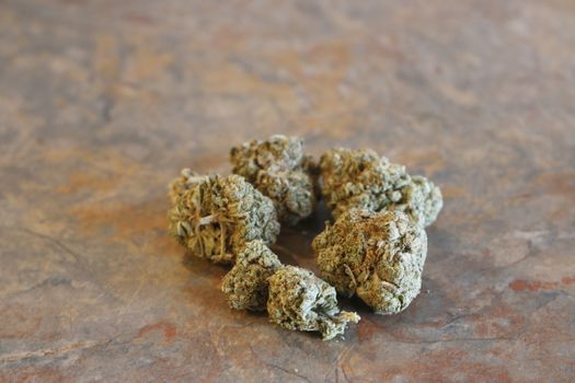group of marijuana buds on a table top.
