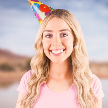 Portrait of a beautiful woman with party hat  against lake