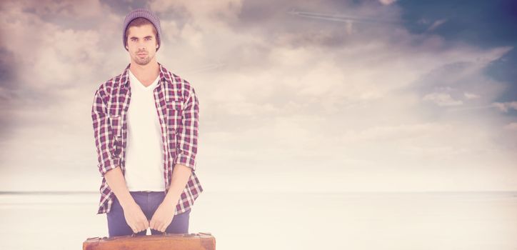 Portrait of confident man holding bag against serene beach landscape