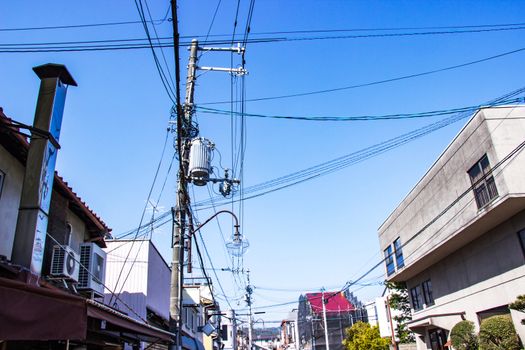 Electric pole with wires and lamp outdoor in the streets organized wiring is neat at Japan bright sky background.