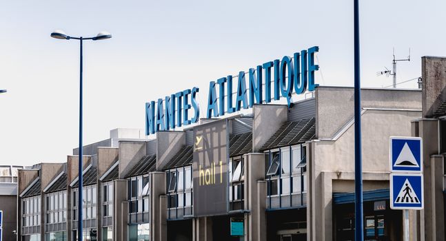 Nantes, France - August 7, 2018: view of the facade of Nantes Atlantique International Airport where travelers are walking on a summer day