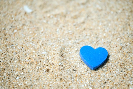 Heart shape on sand at summer beach with copy space. Valentine day concept background.