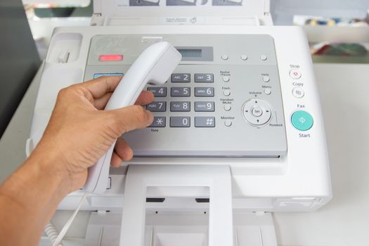 hand man are using a fax machine in the office Business concept