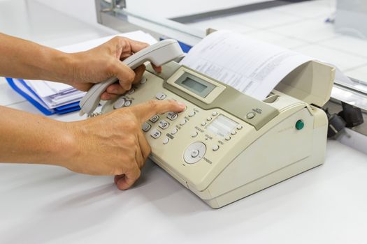 Men are using a fax machine in the office. business concept