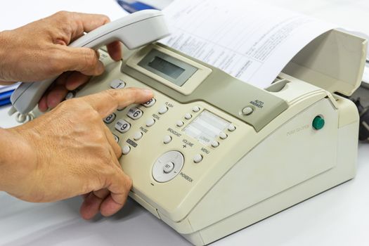 Men are using a fax machine in the office. business concept