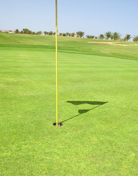 Closeup detail of a golf flag in the hole on a course green
