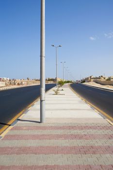 Two lane dual carriageway road in a desert town