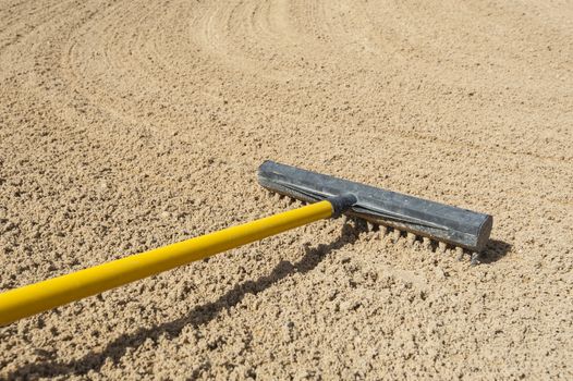 Rake in a bunker on golf course