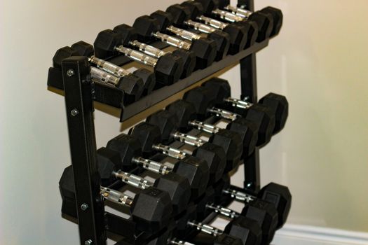 Every size of dumbbell on its rack in a fitness room. Is provided for customers, villagers or livers practice weight training exercise for their muscle strength.