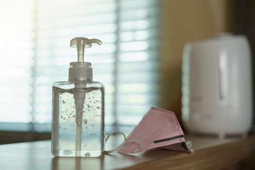 Antibacterial transparent hand sanitizer gel in a plastic bottle with surgical mask.