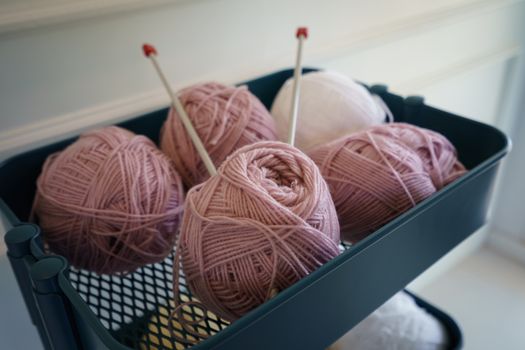 Pink knitting wool and knitting needles.