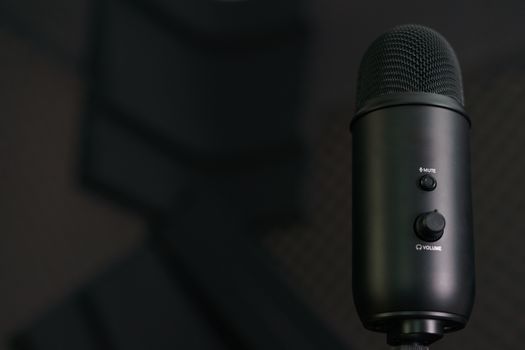 Close-up of professional condenser microphone on a black background.