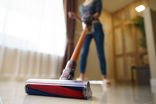 Woman use vacuum cleaner cleaning on floor.