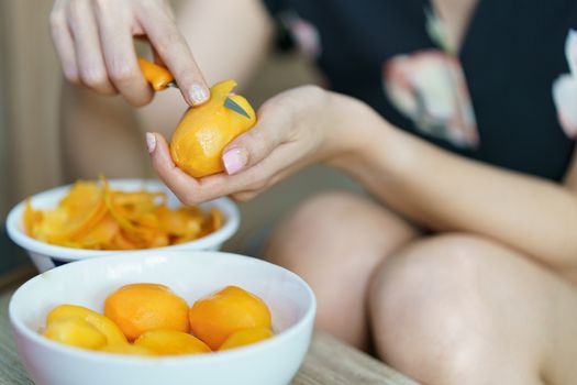 Woman peeling Marian plum or Plum Mango.