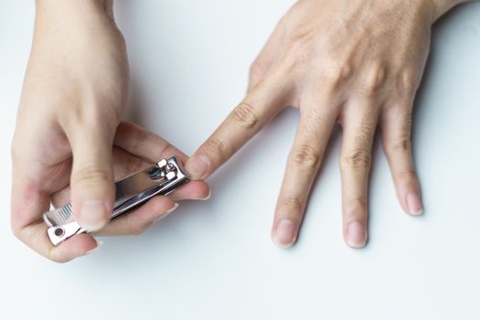 Man using nail clipper clipping her fingernails. white background