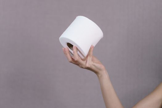 Woman holds rolls of toilet paper in hand