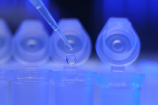 Medical equipment. Pipette adding fluid to one of several test tubes .