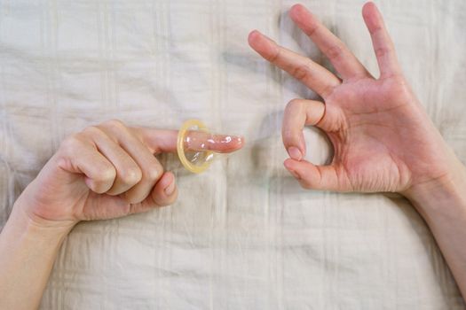 The sex hand sign. women's hands gesture indicating sex and putting condom on her fingers.