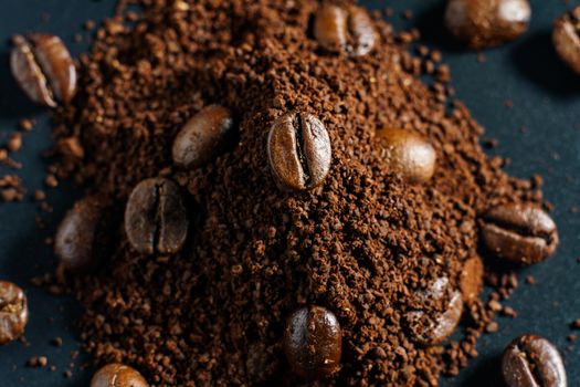 Ground coffee and coffee beans on black background.